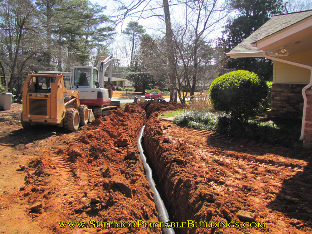 Installing underground drainage pipe.
