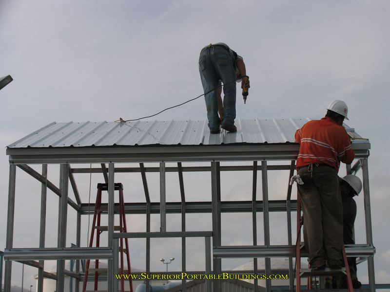 man on steel garage roof